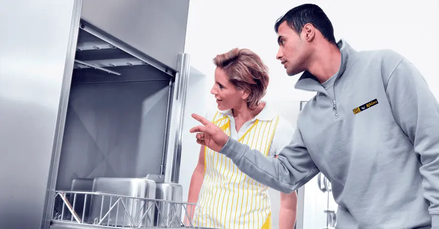 Asesor de ventas mostrando equipamiento de cocinas a una clienta