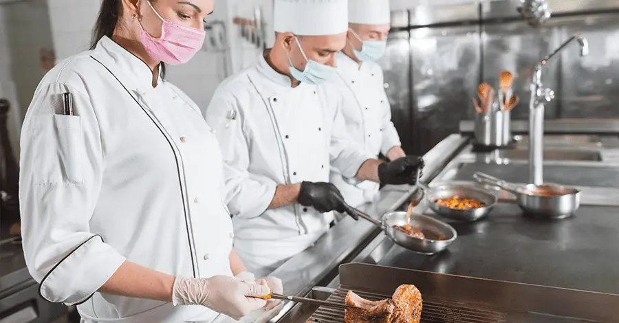 Equipo de cocineros cocinando en un restaurante