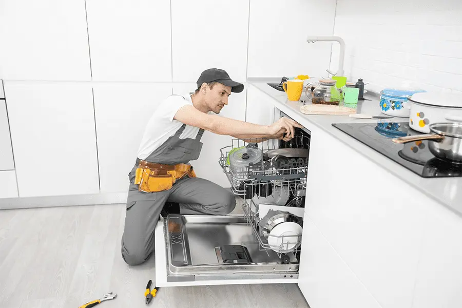 joven técnico realizando la reparación de lavavajillas