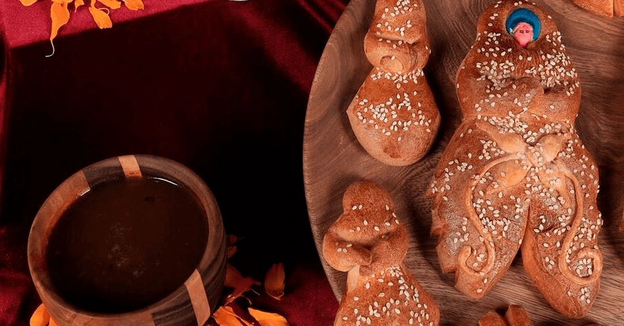Conjunto de panes de muerto junto a un café en una mesa de ofrenda de día de muertos